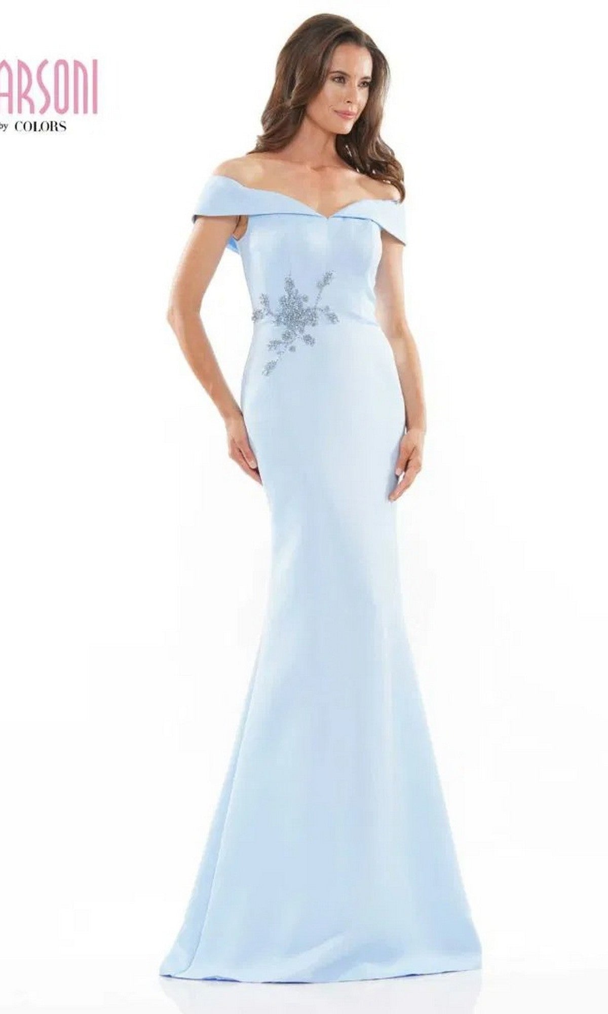 A woman wears the Marsoni MV1003 long formal dress in sky blue, featuring an off-the-shoulder satin design with beaded floral embellishments on the bodice.